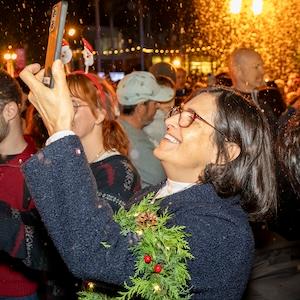 Woman taking a photo at a Christmas tree lighting